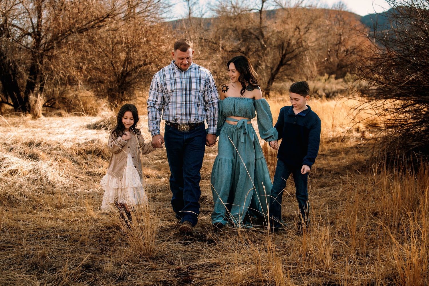 A tender wedding moment captured against a rustic stone building backdrop.