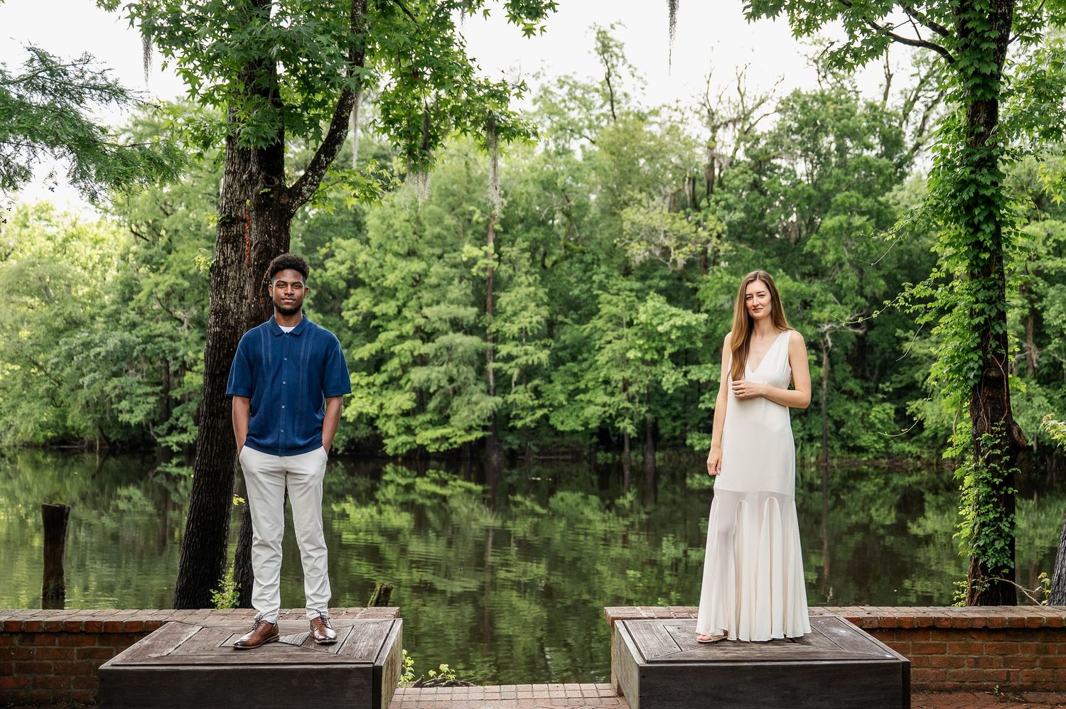 Couple posing for engagement photos in a beautiful outdoor garden setting.