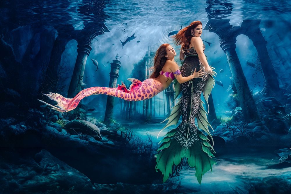 A mermaid swims gracefully through a mystical underwater forest scene with ethereal blue lighting and floating bubbles.