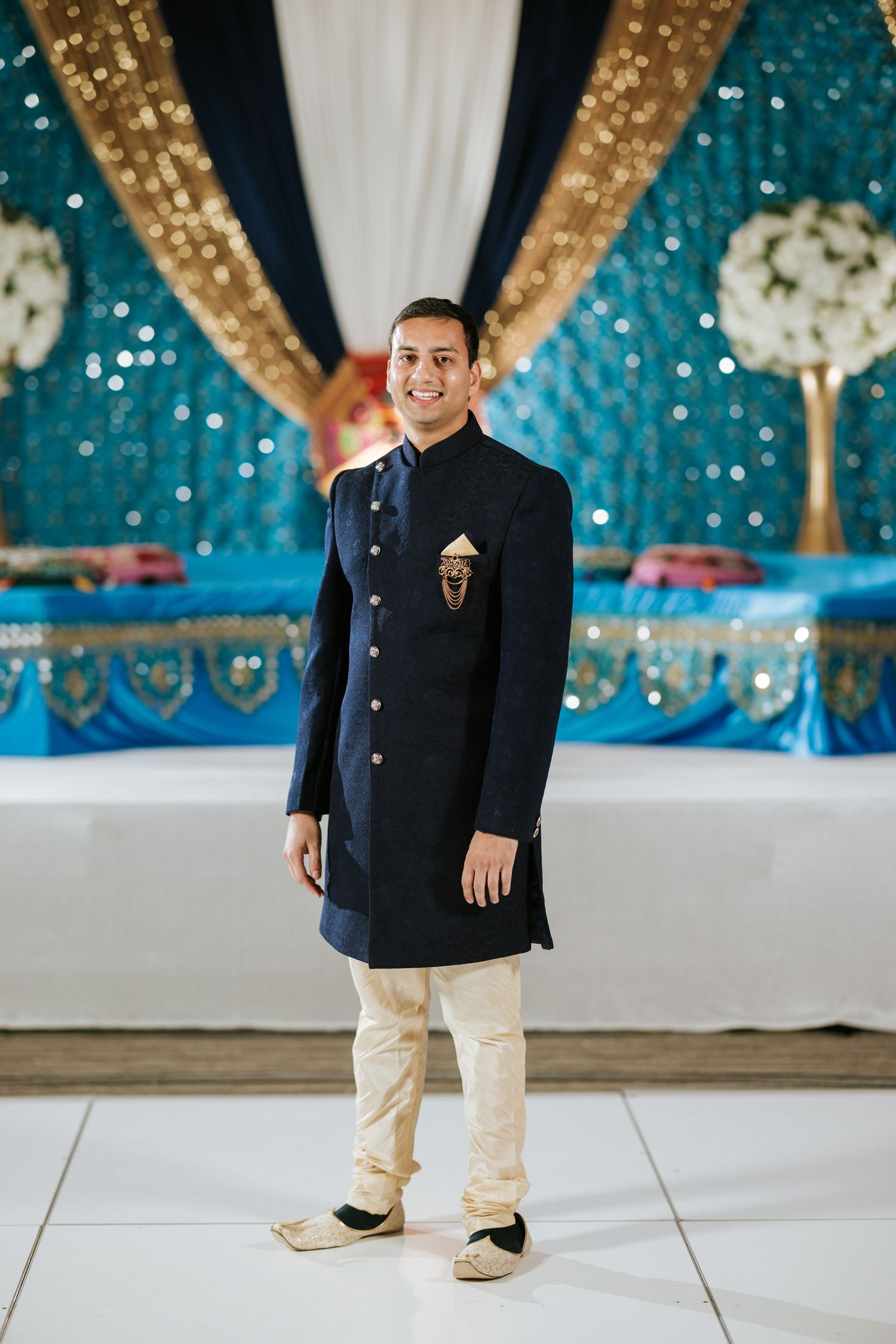 A sequence of photos showing someone in a black formal suit and beige pants at an elegant event with blue decor.