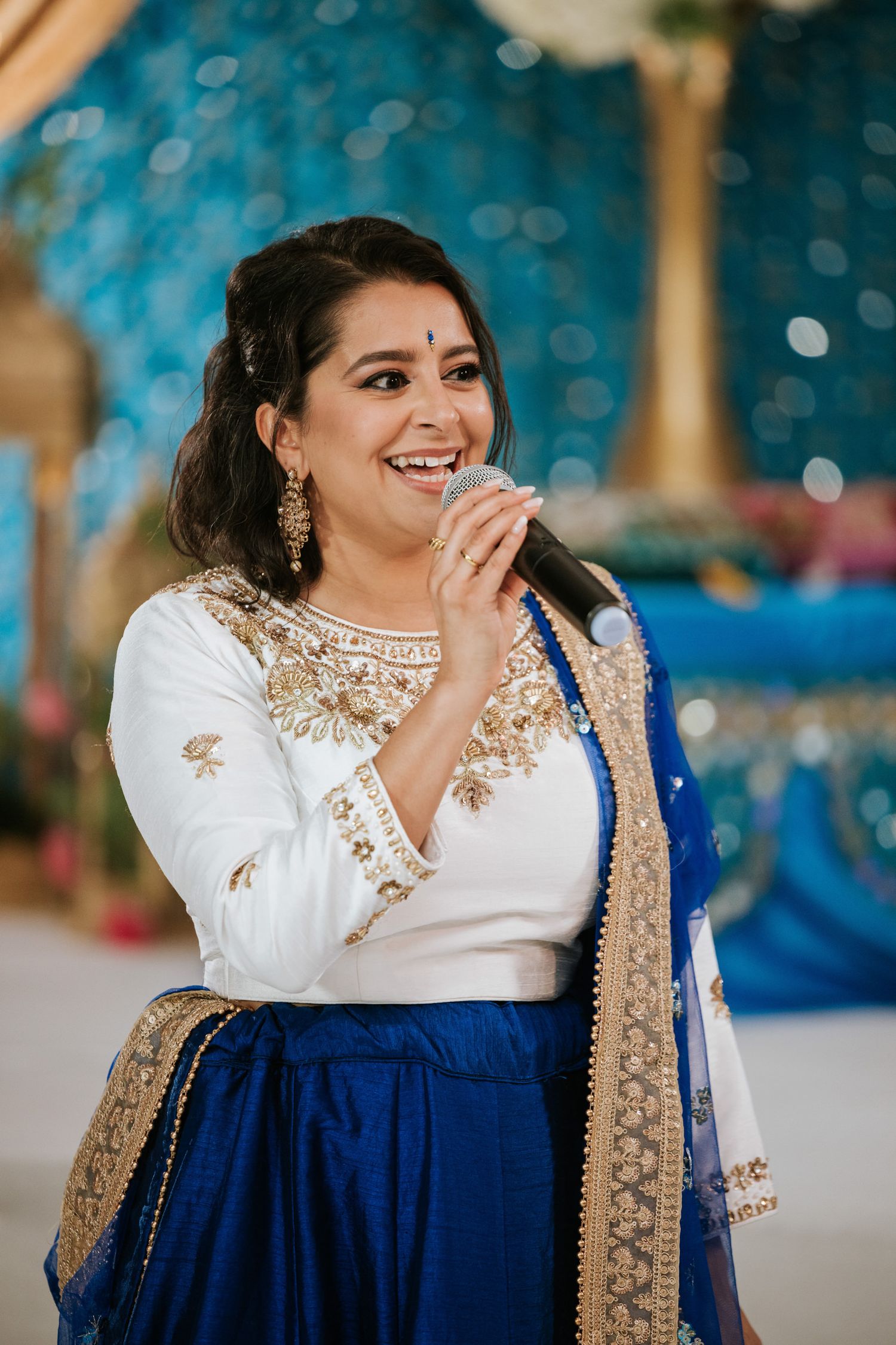 A series of joyful moments captured in traditional Indian attire featuring a navy blue and white embellished ensemble.