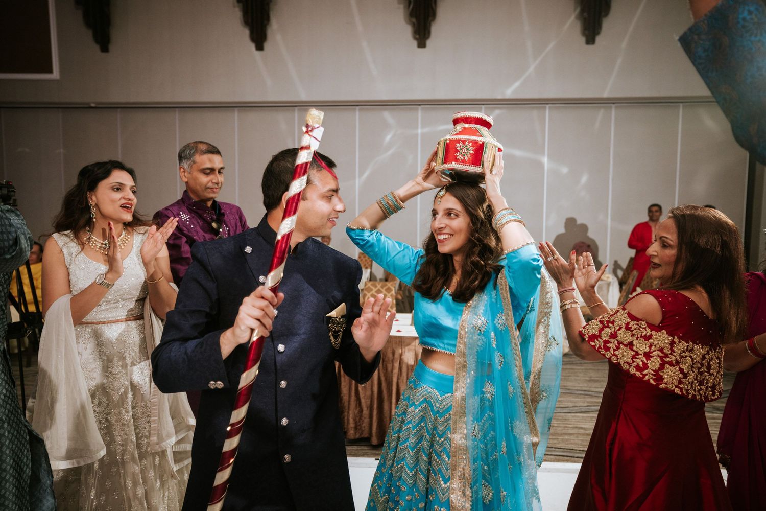 Wedding guests dancing and celebrating on a dance floor at an Indian reception.