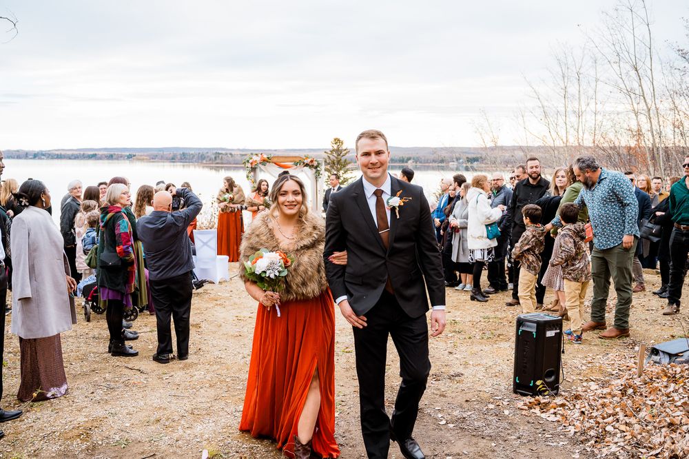 Wedding party and guests gather on a scenic autumn lakeside beach for outdoor celebration photos. Seba beach Wedding photographer