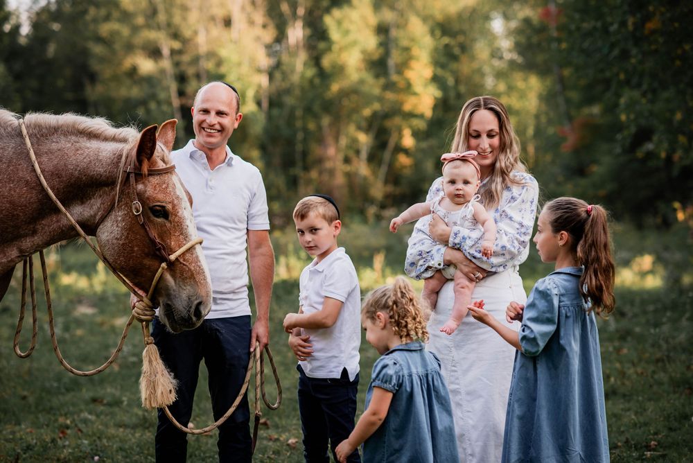 A family engaging and meeting a horse during family photos at a ranch in Bolsover, Ontario.