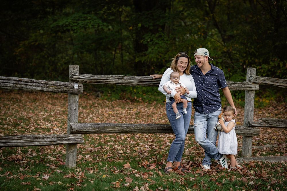 A family posing with their toddler and infant during their first family photoshoot as a new family of four in Bolsover, Ontario.