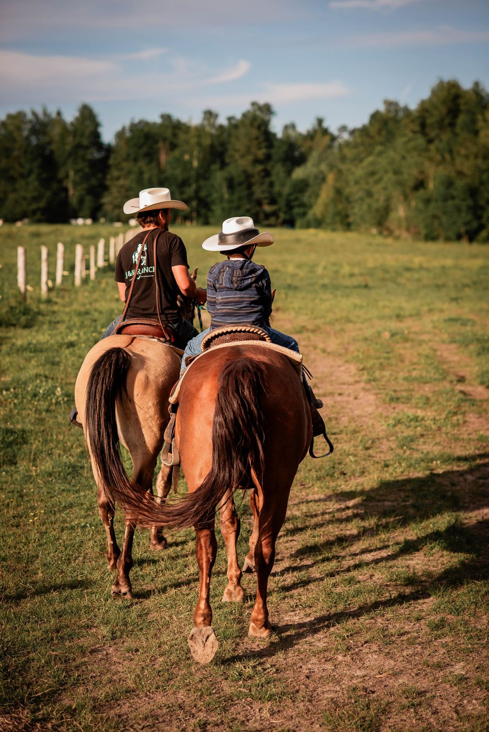 A young boy being guided on horseback during a sunset trail ride in Bolsover, Ontario.