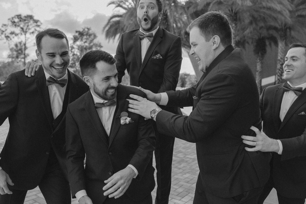 A series of black and white wedding photos showing emotional moments and embraces between people at a celebration.