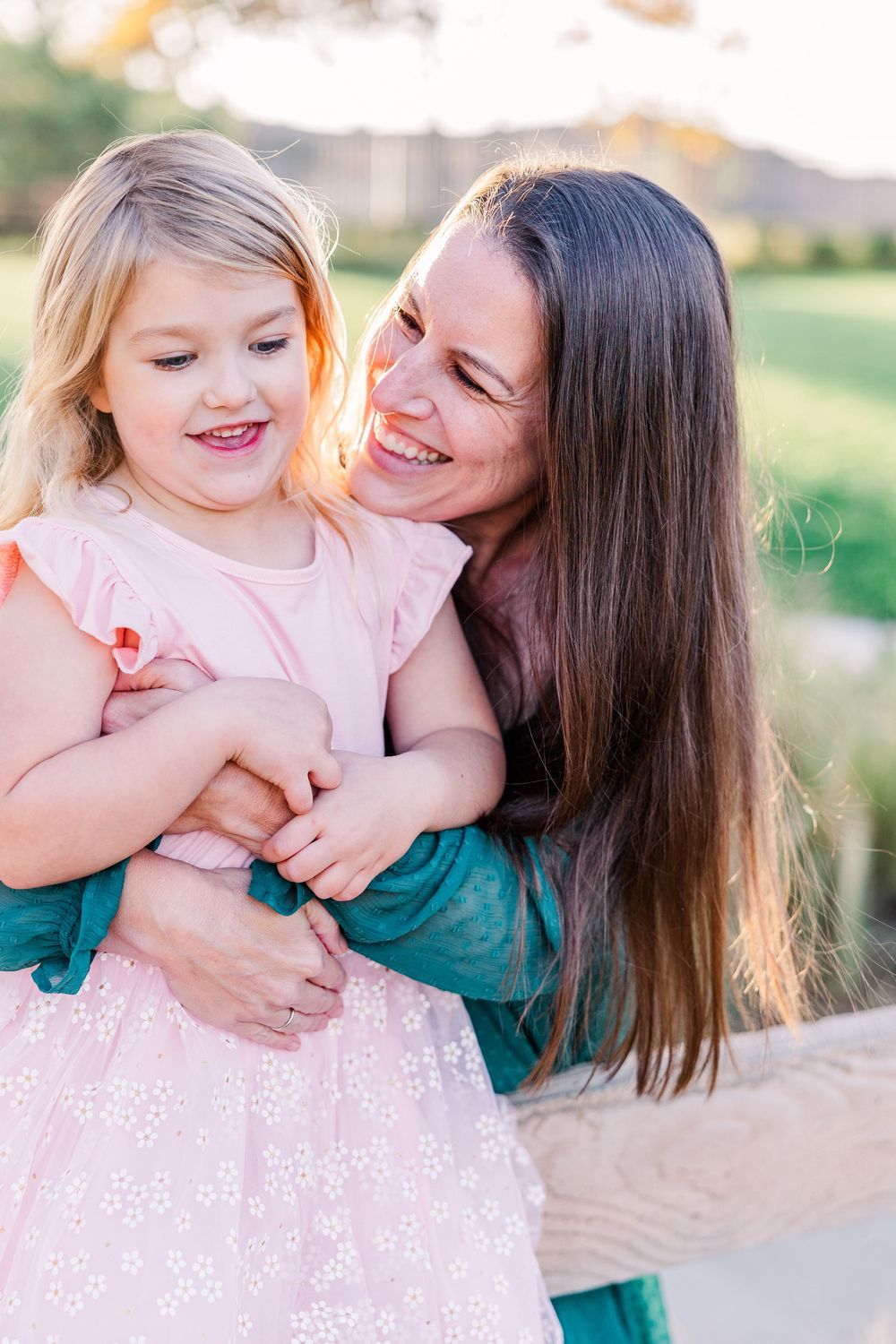 A tender outdoor portrait showing joyful expressions and embraces in soft natural lighting during golden hour.
