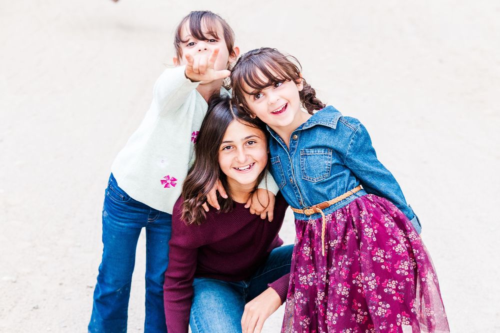 A family in coordinated outfits sharing a joyful moment together against a white background.