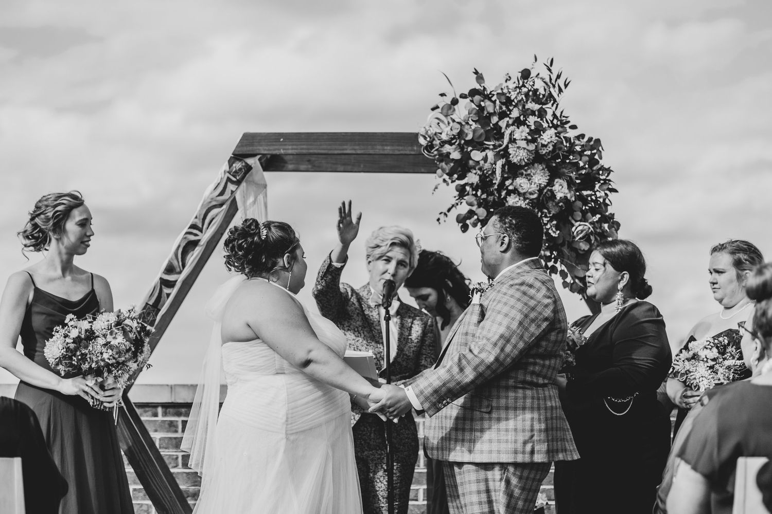 A black and white photo montage shows wedding guests celebrating and embracing during an outdoor reception.