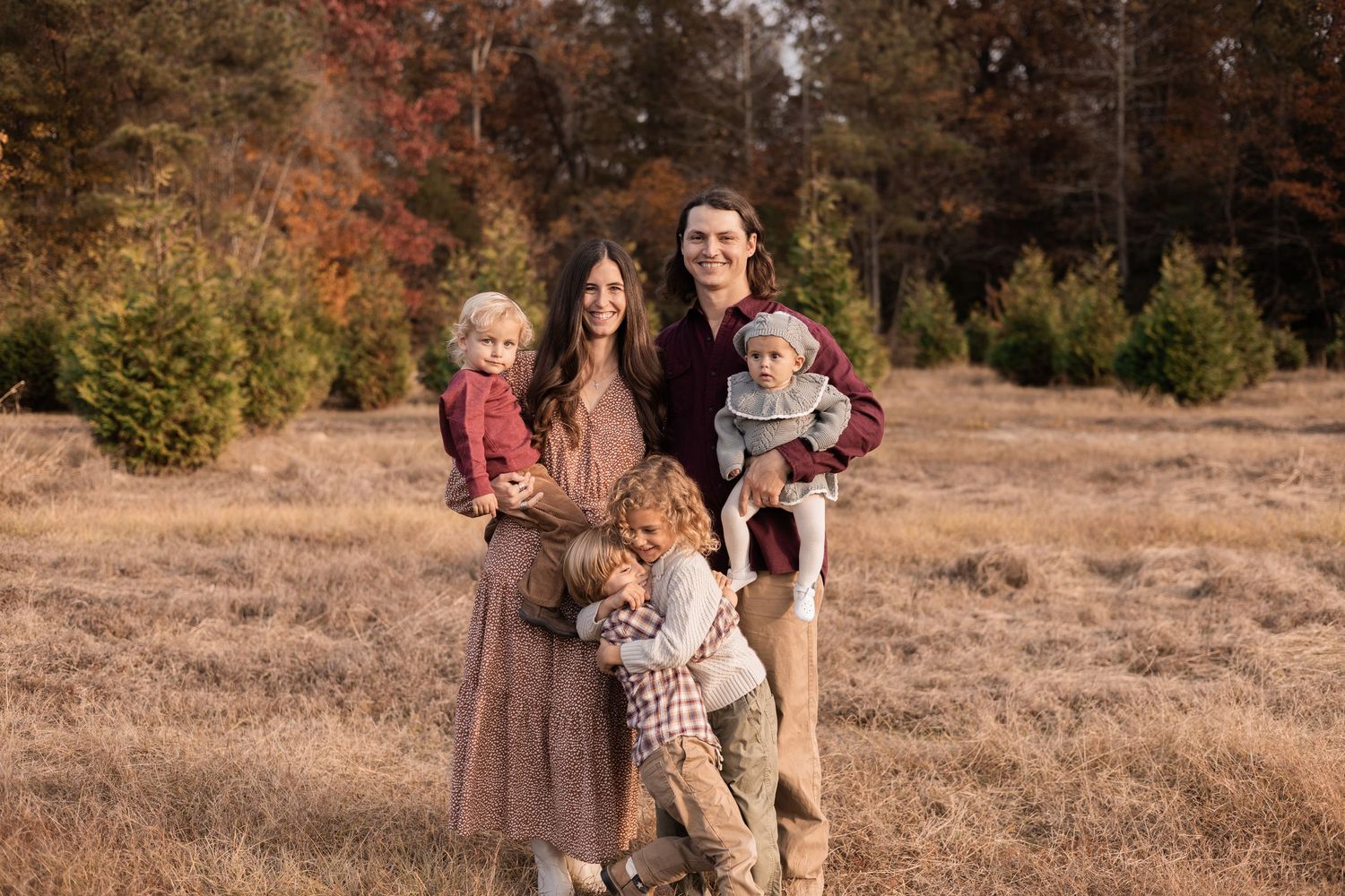 Wilmington family photoshoot, mom and dad holding the younger two kids and brothers are standing hugging each other