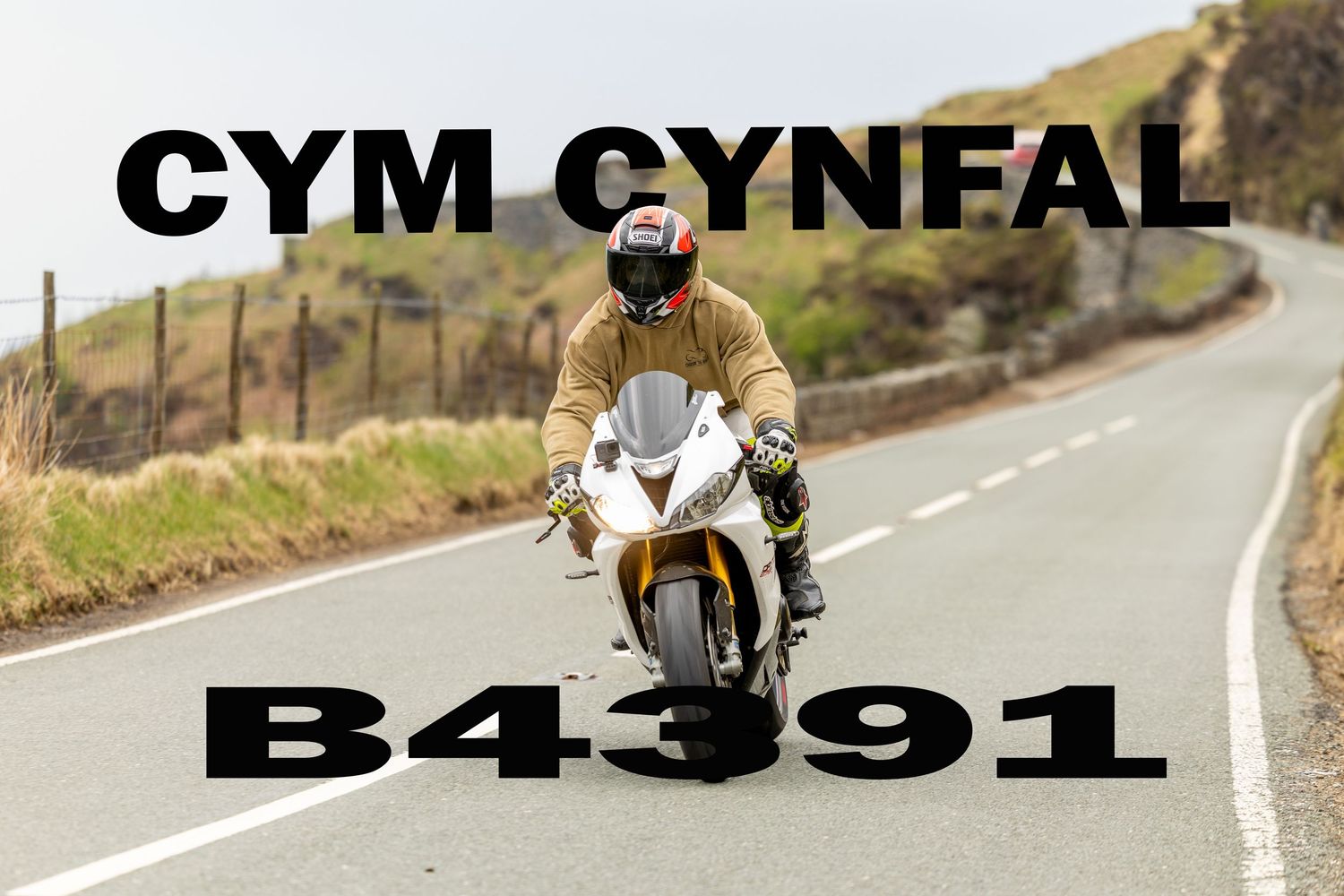 A motorcyclist rides a Monyash B5055 bike on a rural country road with another rider visible in the distance.