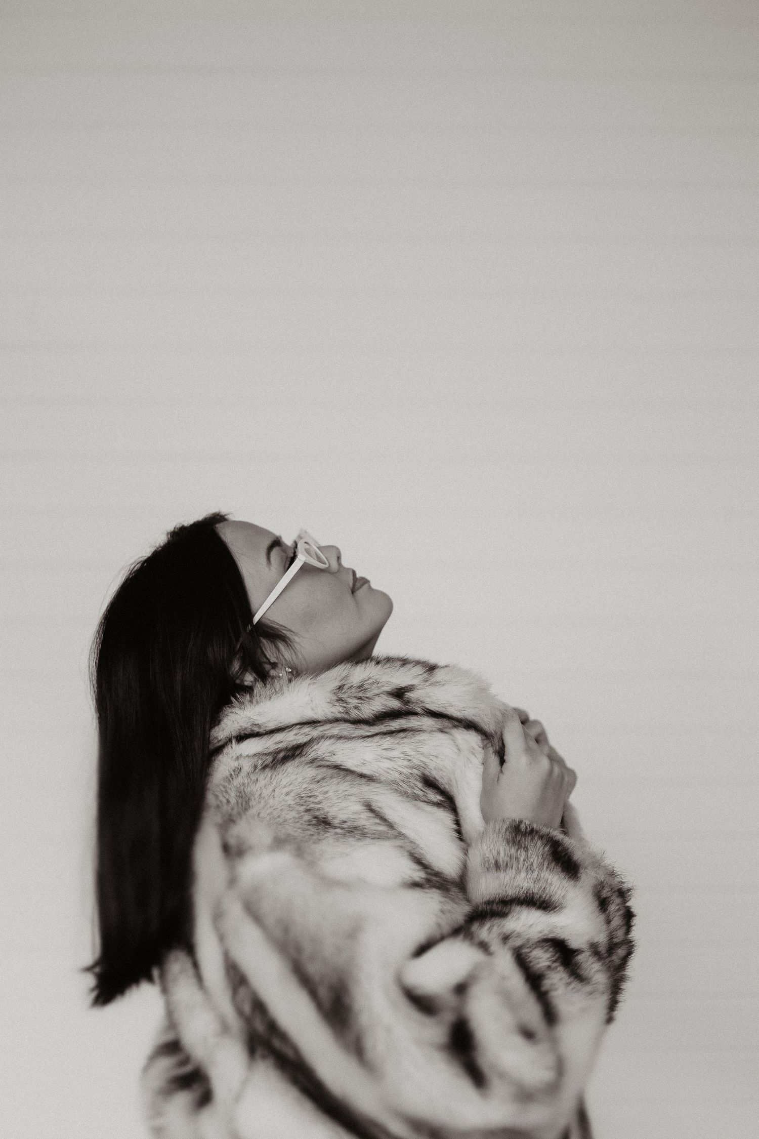 Black and white artistic portrait series showing a person with long dark hair in different expressive poses against white background.