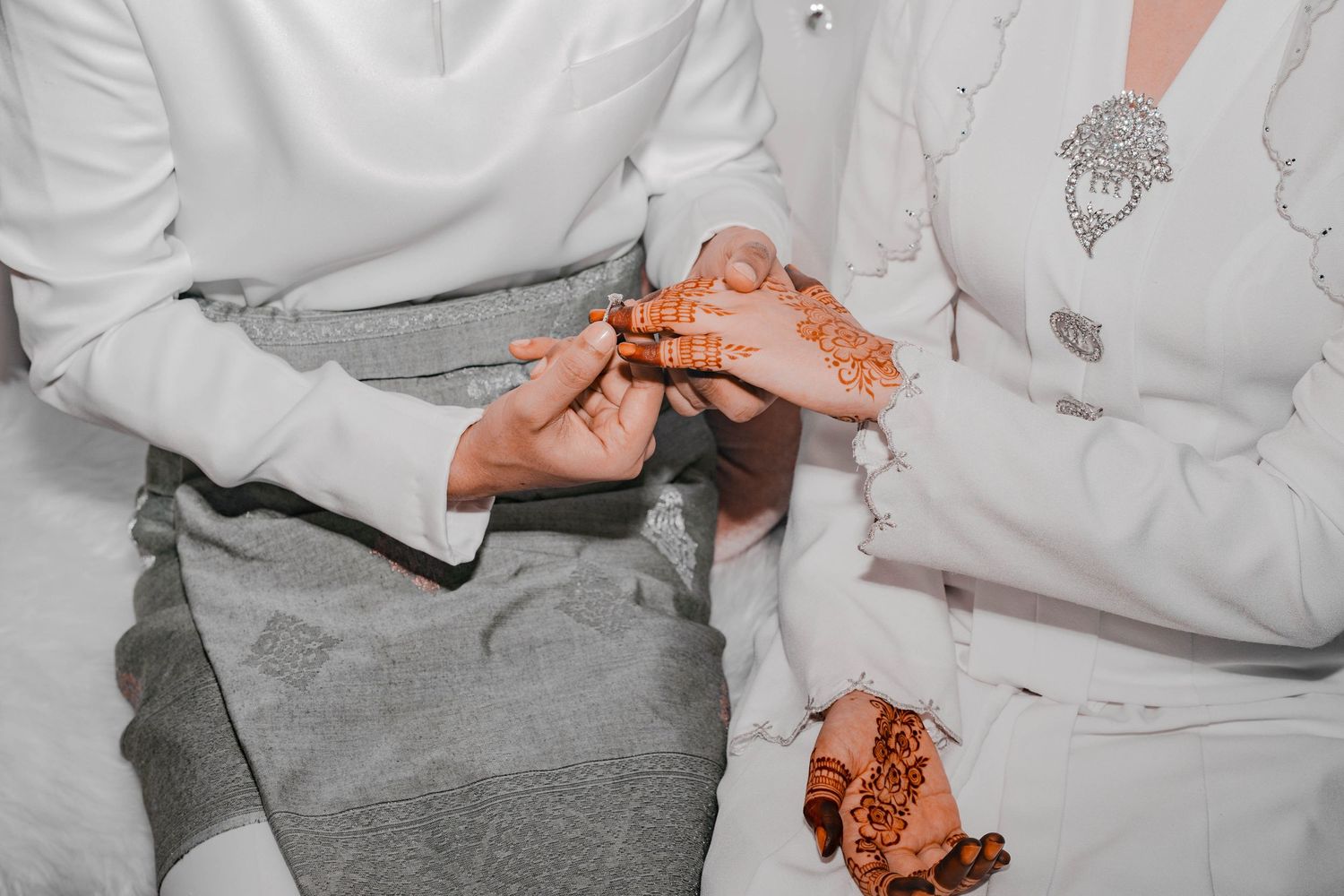 Close-up of hands with traditional henna designs during a wedding ceremony.