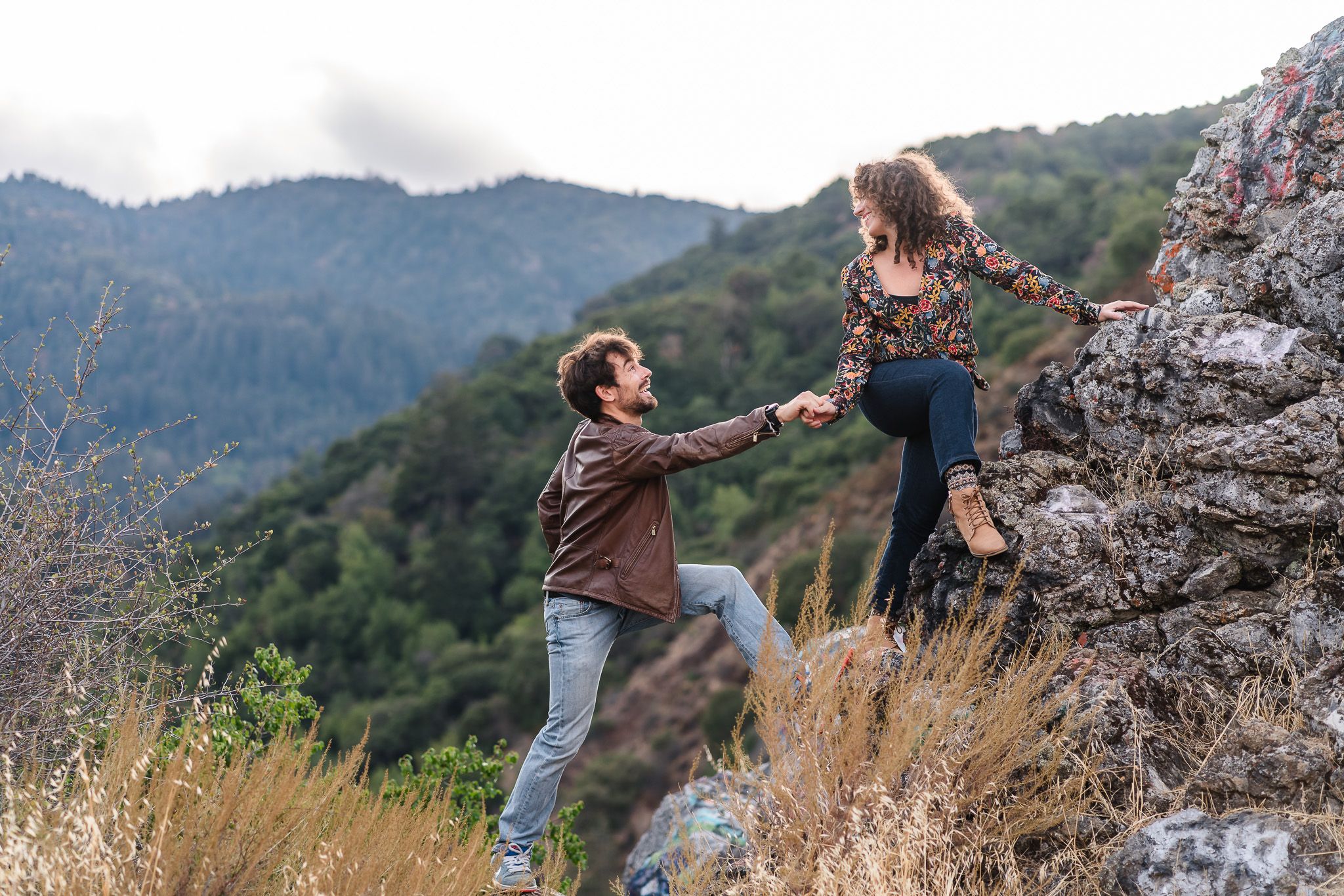 Couple shares tender moment while hiking on rocky mountain trail. Located near Felton.