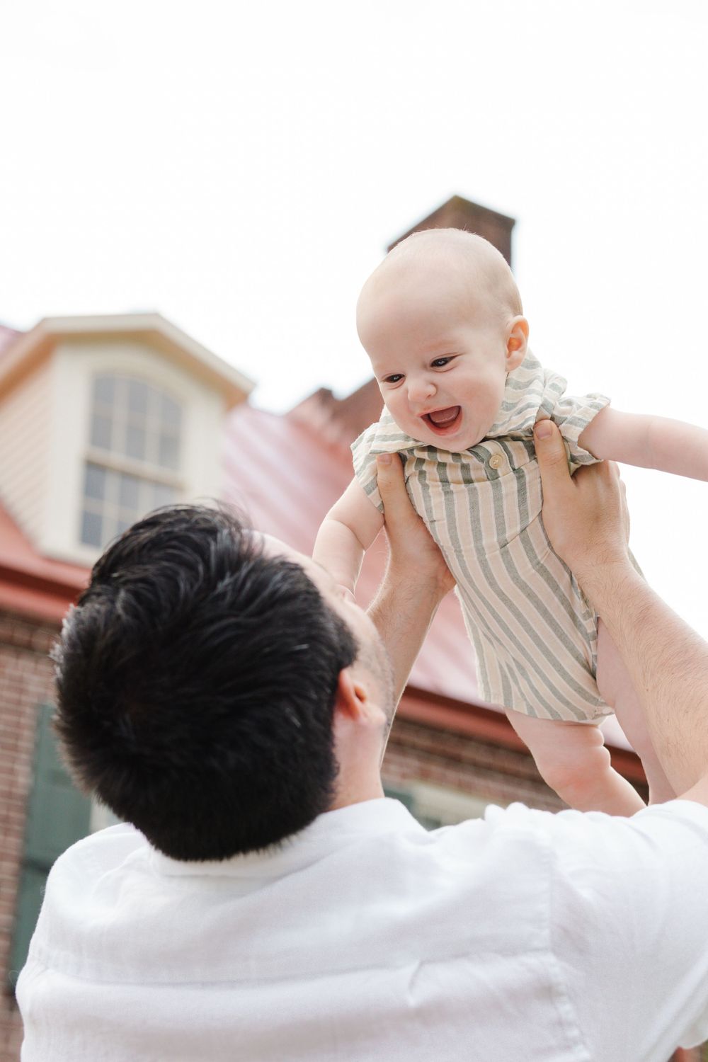 Daddy playing airplane with his baby as they pose for family photography at Barclay Farmstead in Cherry Hill, NJ.