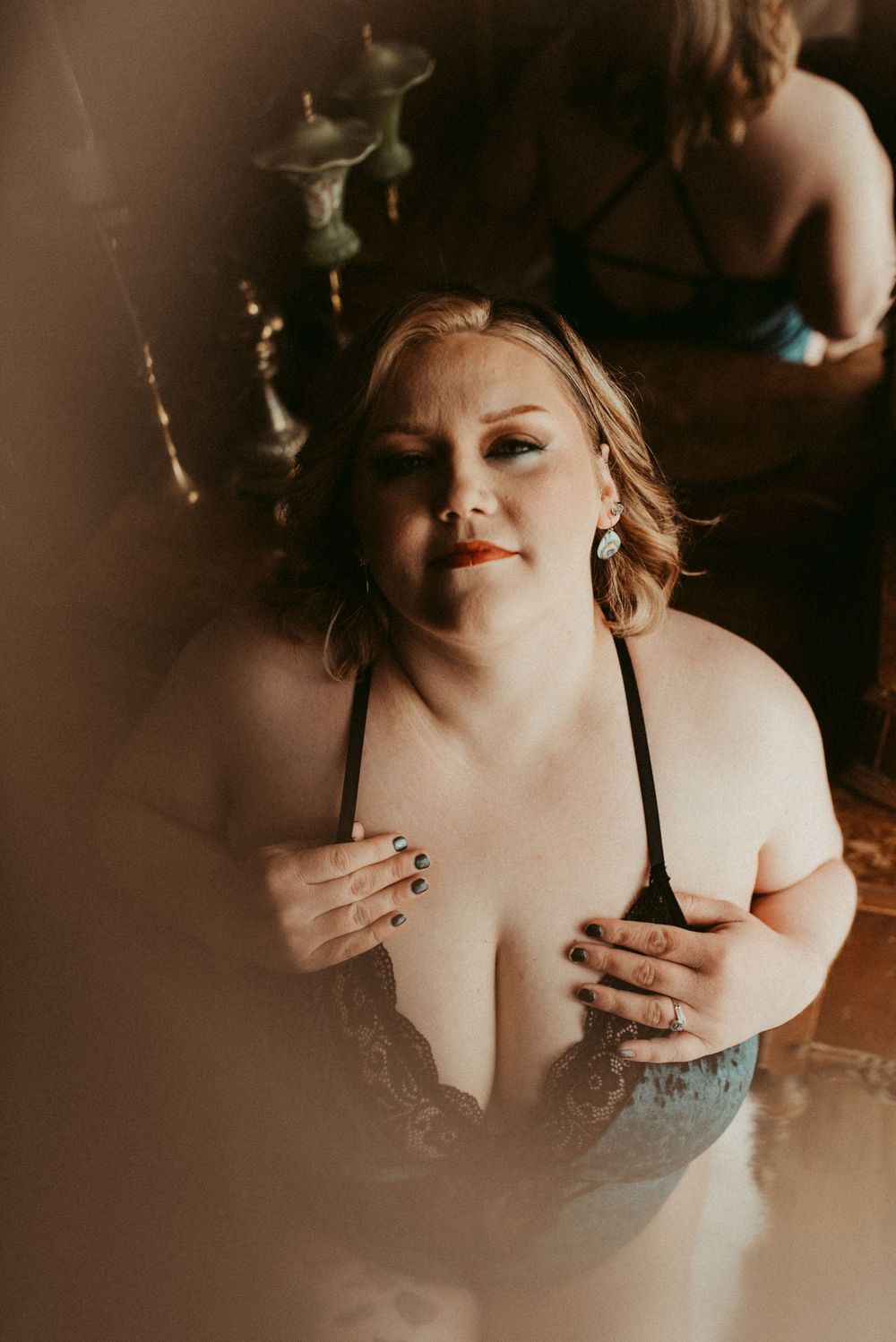 Intimate boudoir portrait in moody lighting with lace details.