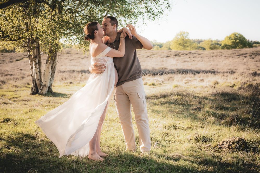 A romantic dance in a sunlit meadow with flowing white dress and casual attire.
