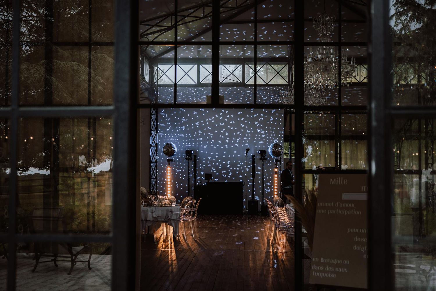 Modern glass restaurant interior decorated with glowing string lights creating a warm ambiance at night.