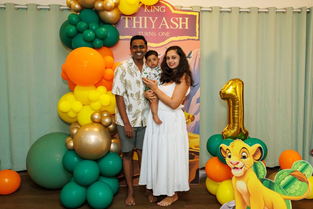 Lion King themed first birthday party setup with balloon arch and decorative backdrop.