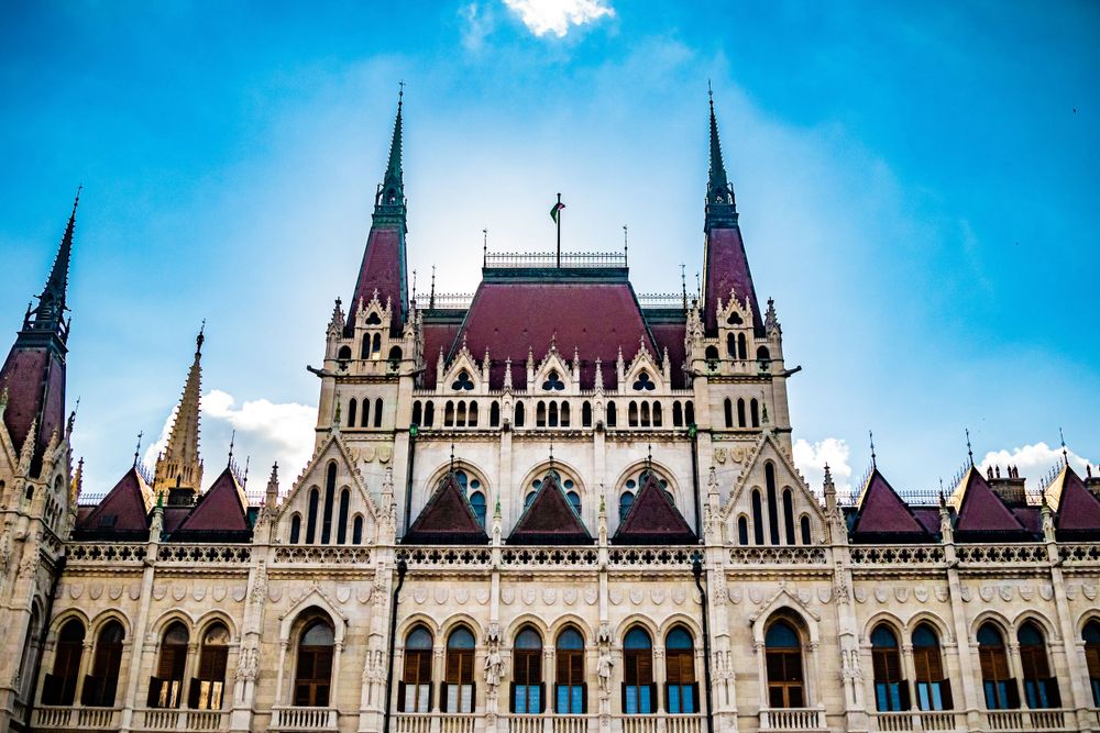 Detailed Gothic architecture of the Budapest Parliament Building with pointed spires and arched windows.