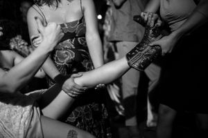 Black and white image showing people dancing and pouring drinks at a party or club.