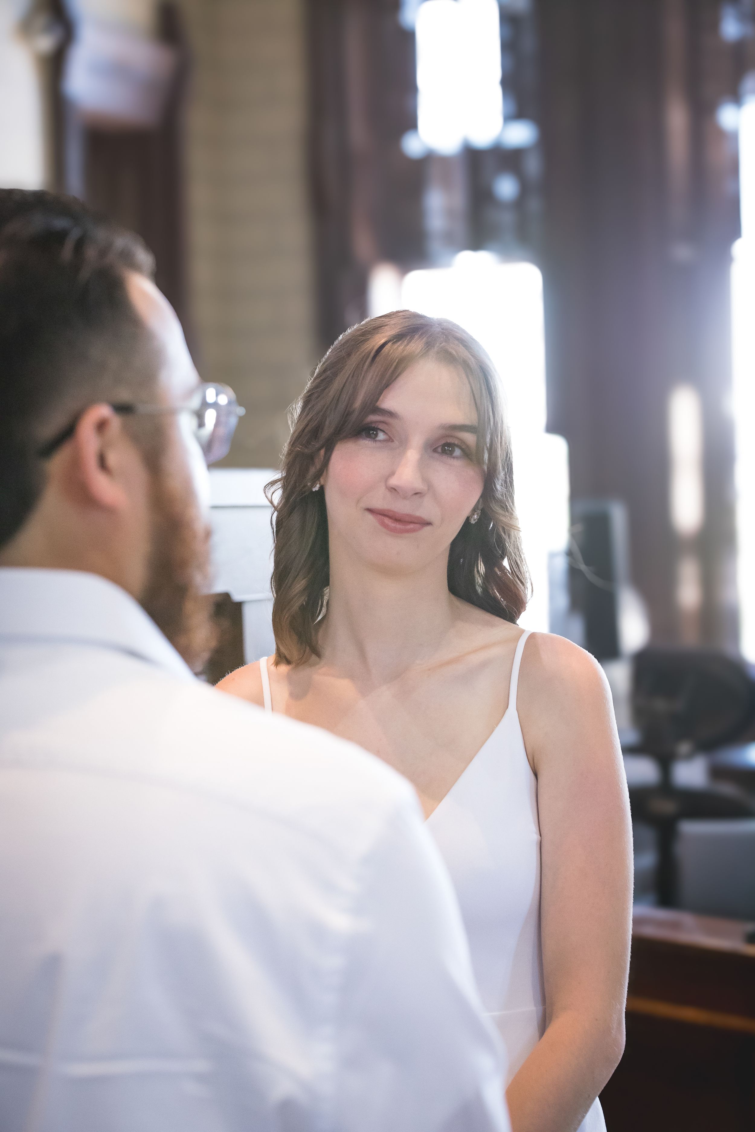 Wedding ceremony sequence showing intimate moments in front of wooden paneled walls.