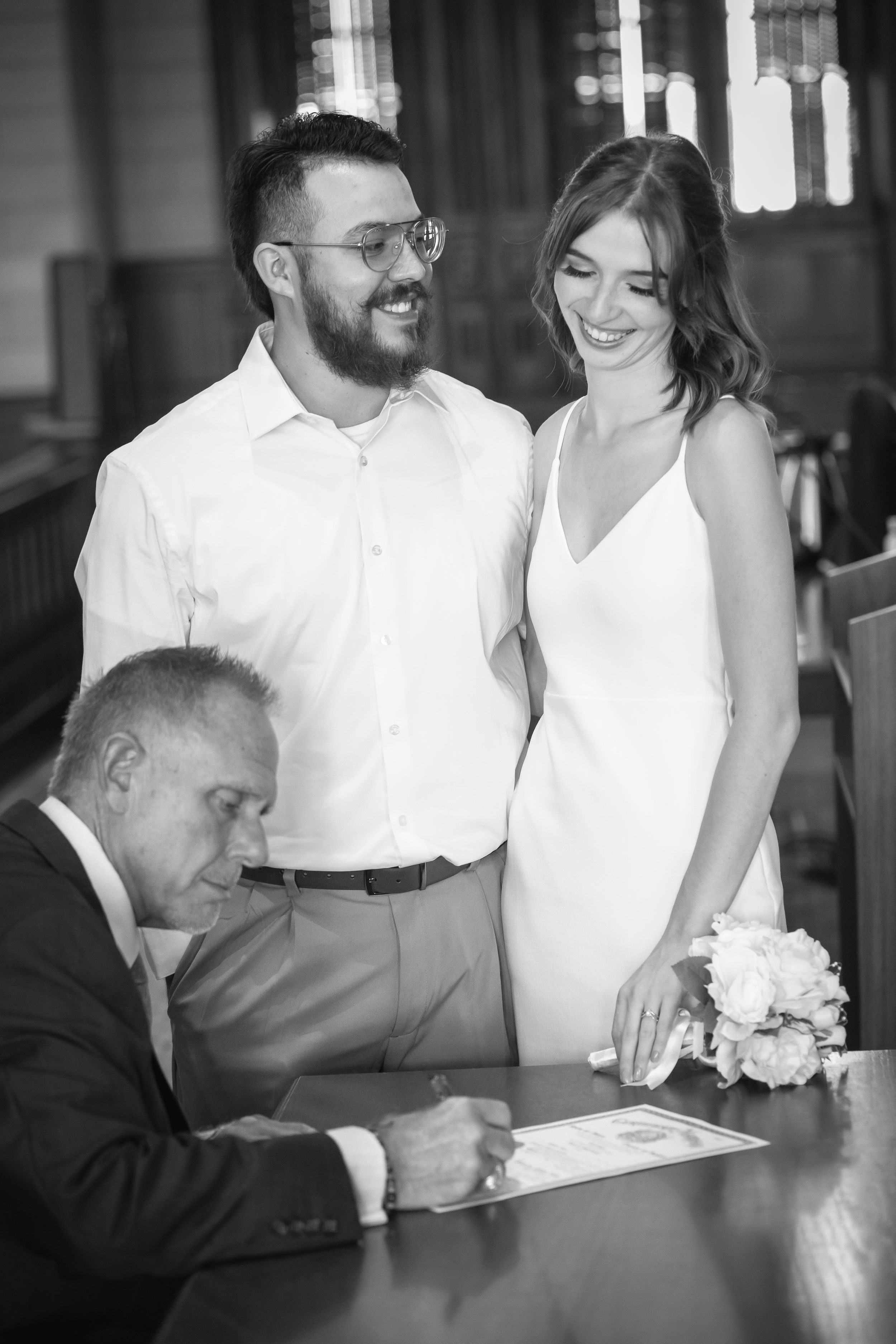 Black and white wedding ceremony photos with couple and officiant at wooden podium.