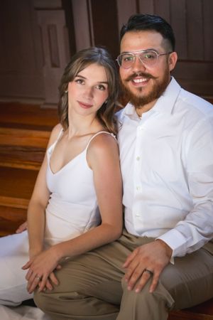 A couple in white and khaki sits together for an intimate wedding portrait.