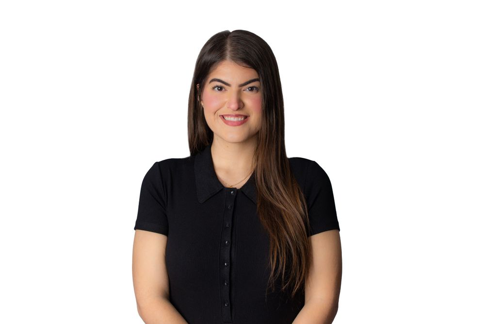 Professional headshot of a woman in black button-up top against neutral background.