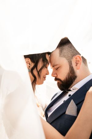 couple under viel with forehead together