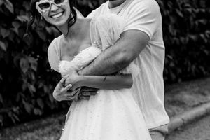 Groom hugging bride from behind