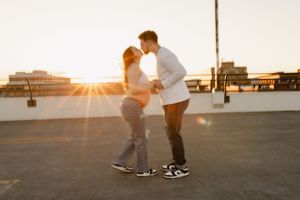 Golden sunset silhouettes against an urban rooftop creating a romantic ambiance.