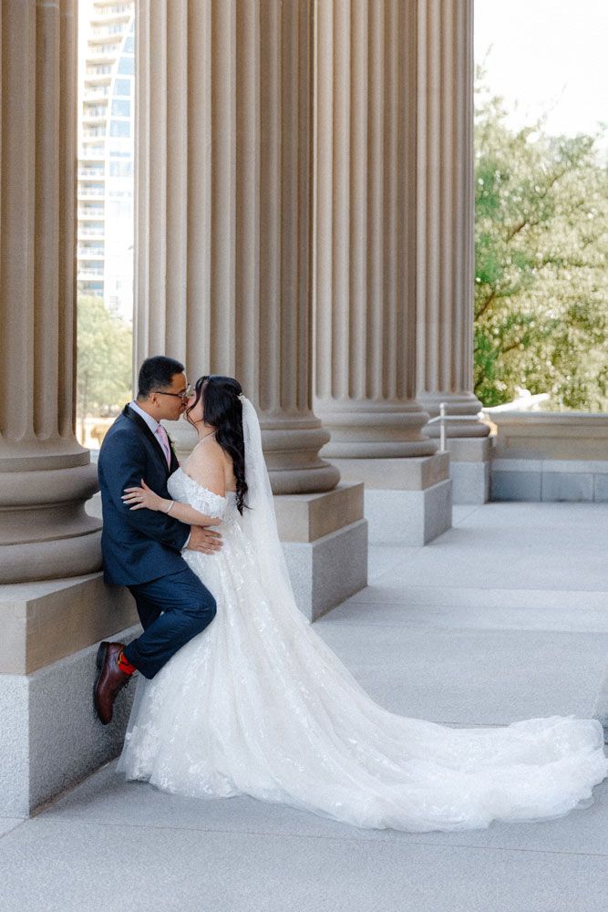 Bride and groom share a romantic kiss at the Alberta Legislature Building in Edmonton.