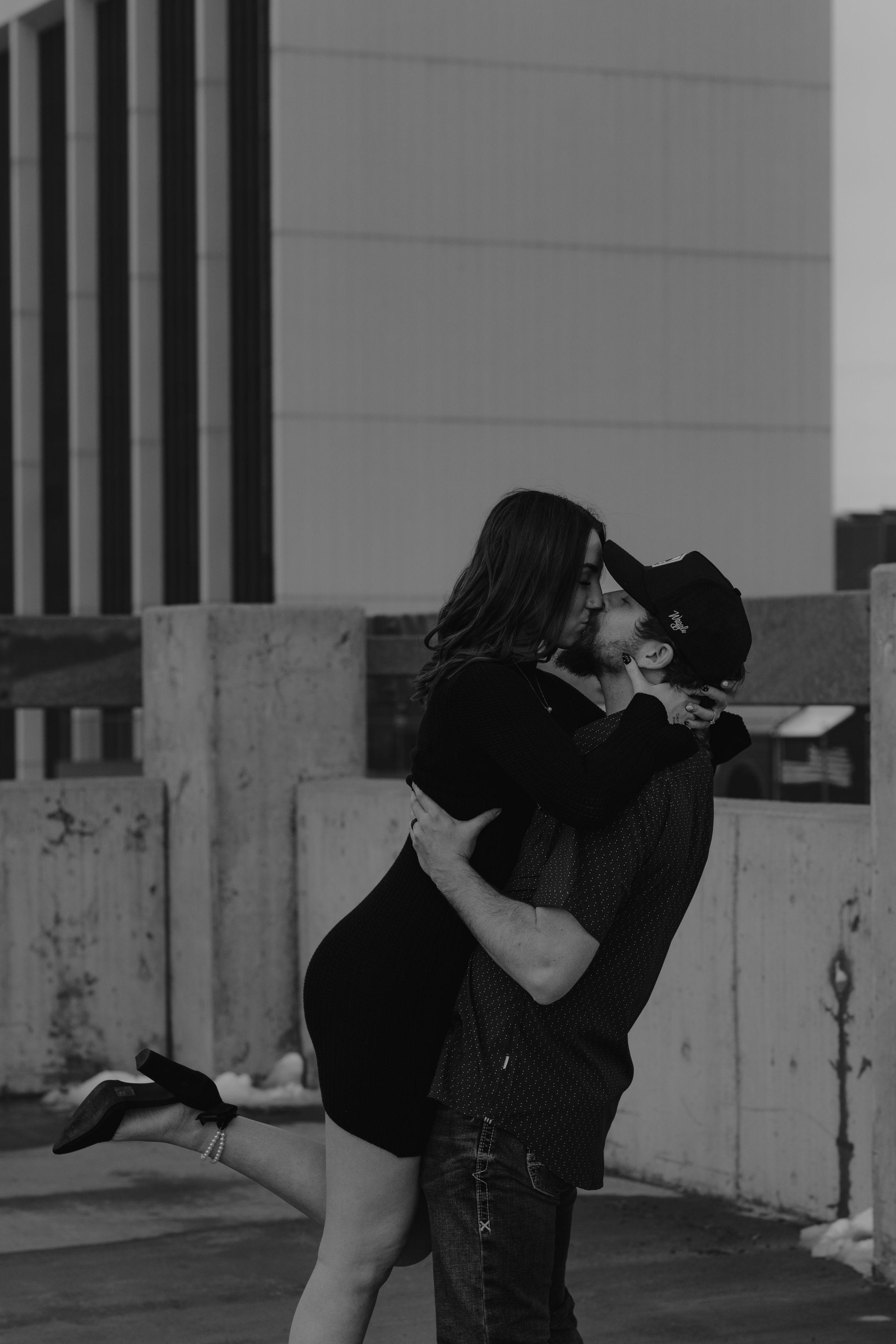 A romantic couple embracing in black and white, with her being lifted in a passionate moment.