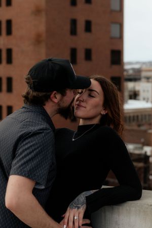 Romantic rooftop moment captured against an urban brick building backdrop in the city.