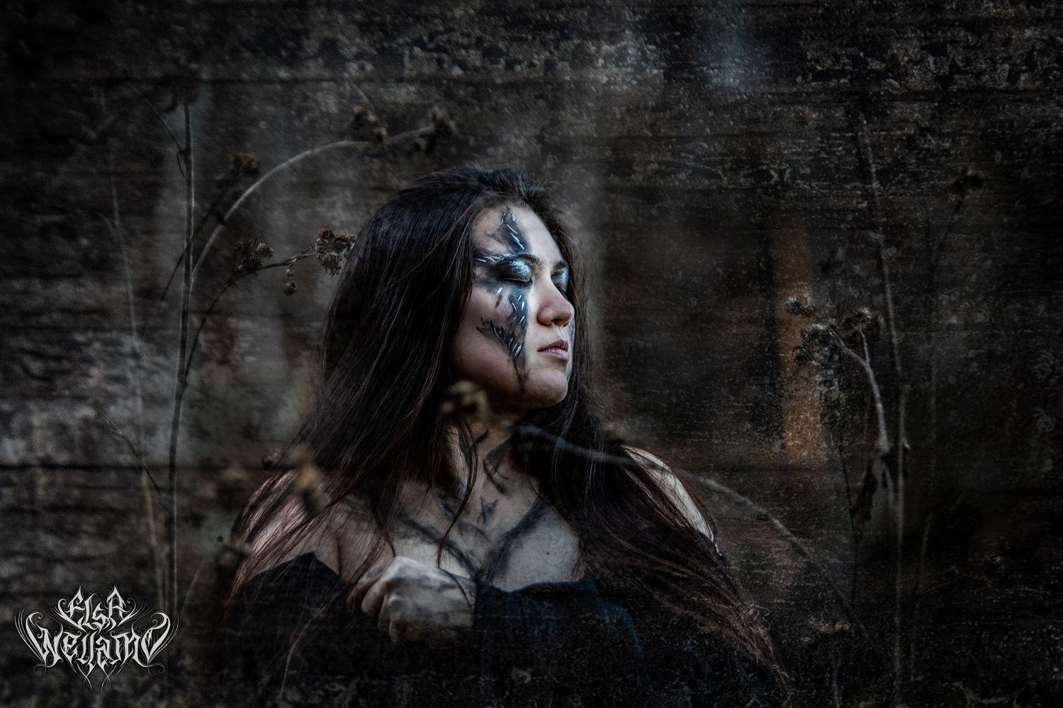 Dramatic moody portrait against textured dark wall with artistic lighting and ethereal atmosphere.
