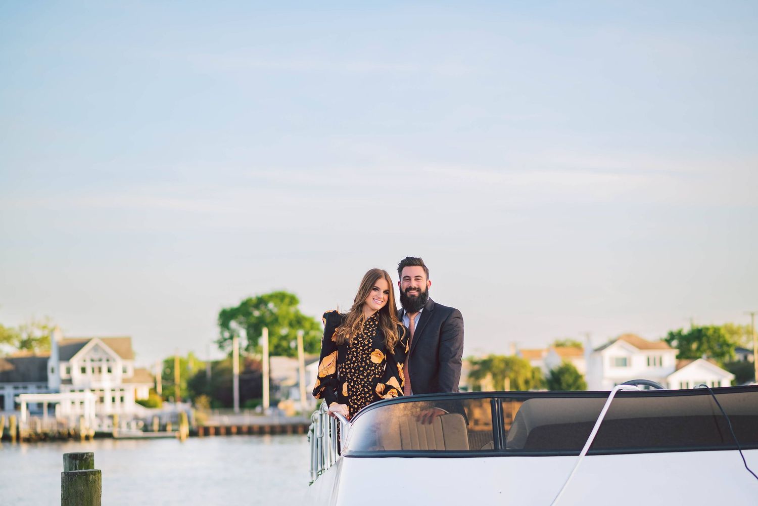 Scenic waterfront wedding venue with boats and docks in the background during golden hour.