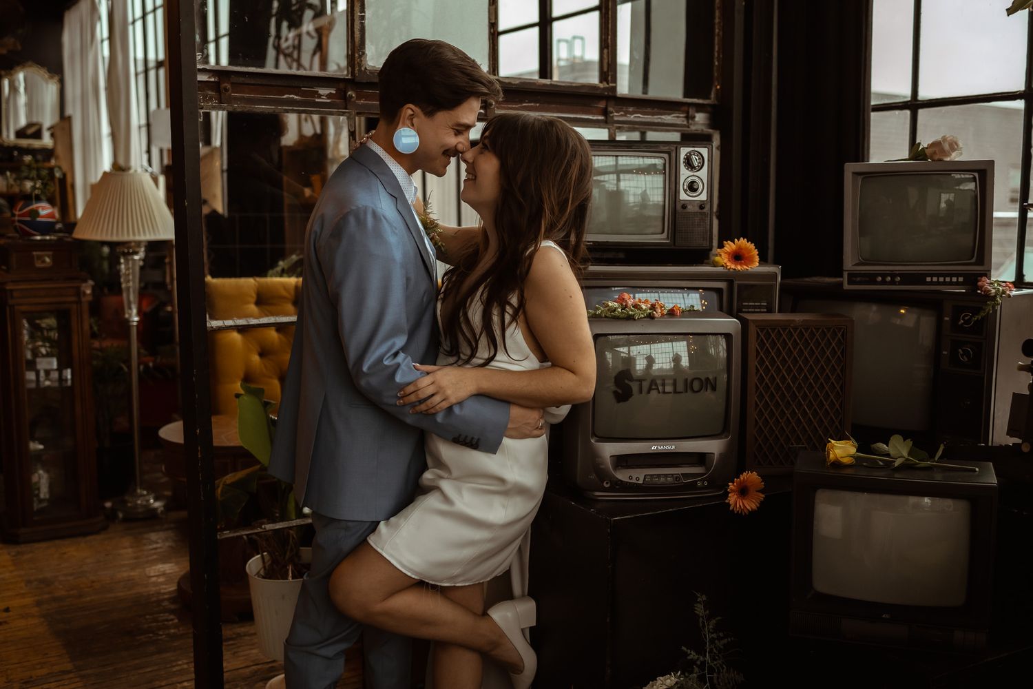 An intimate moment between a couple in casual attire inside a vintage-styled room.