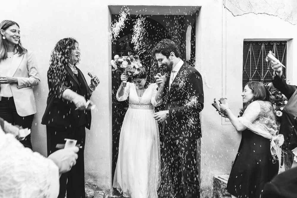 Coppia di sposi esce dalla chiesa durante il lancio del riso