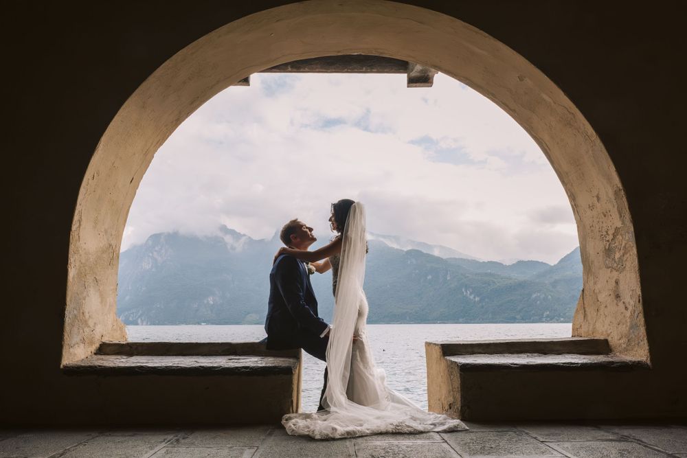 Coppia di sposi sotto un arco affacciato sul Lago di Como