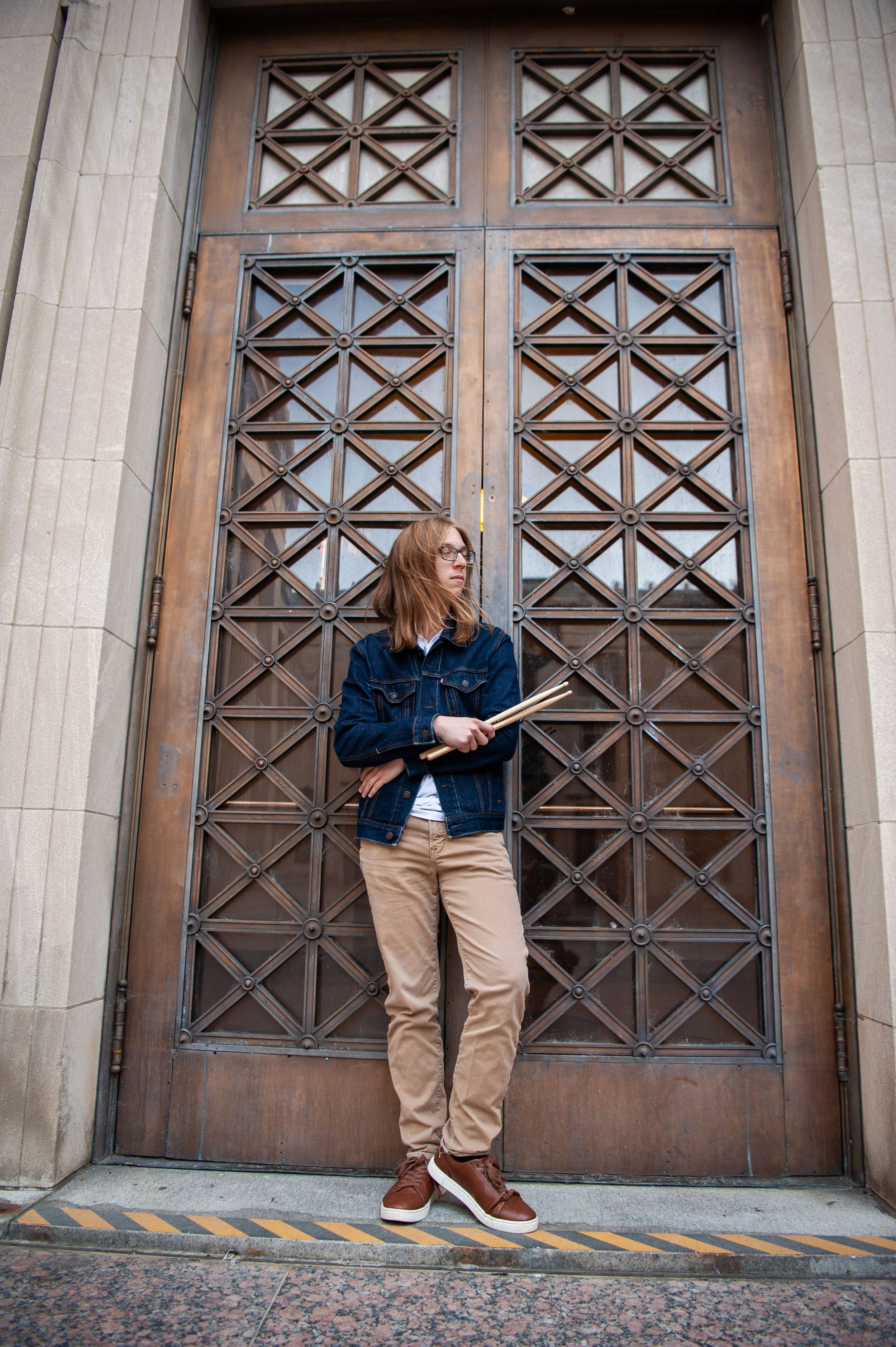 A person poses in casual wear against decorative wooden doors with geometric patterns in a series of artistic shots.