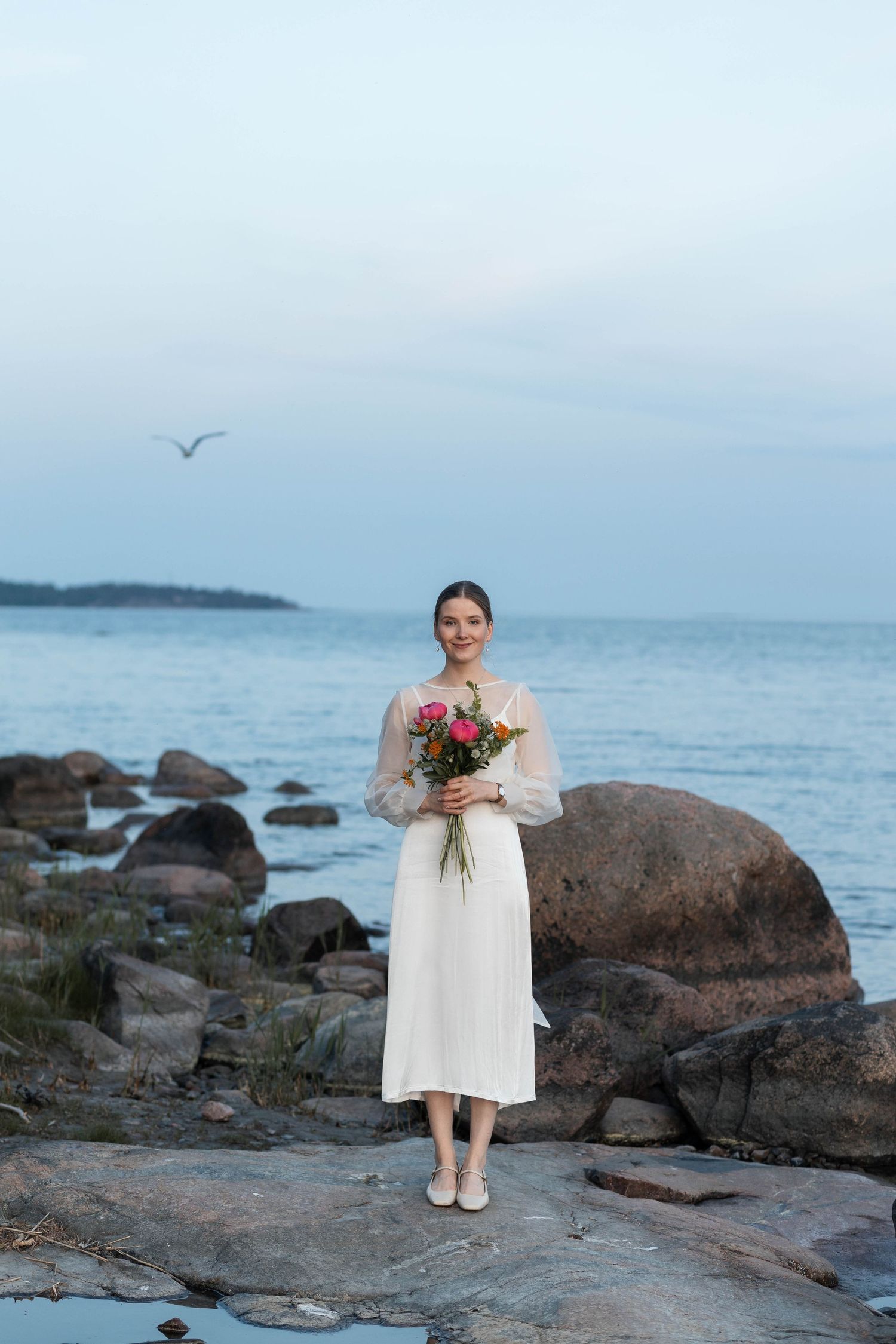 Morsian hääpuvussa auringonlaskun pehmeässä valossa.