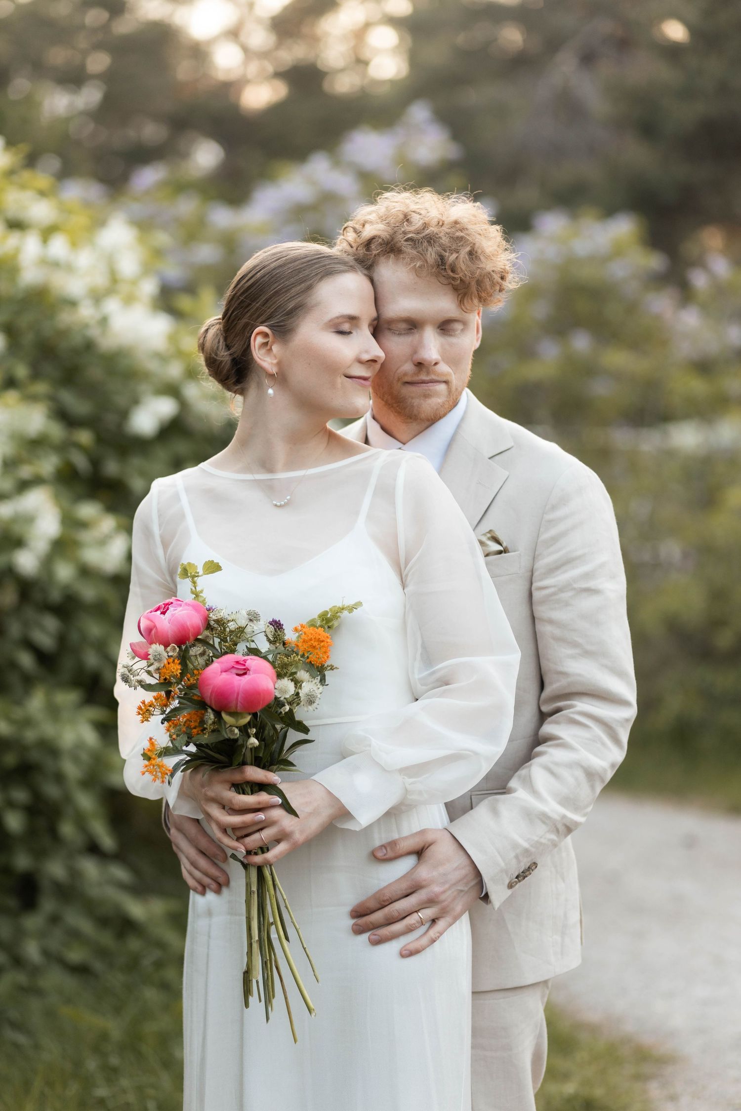 puolivartalokuva hääparista syreenijen edessä