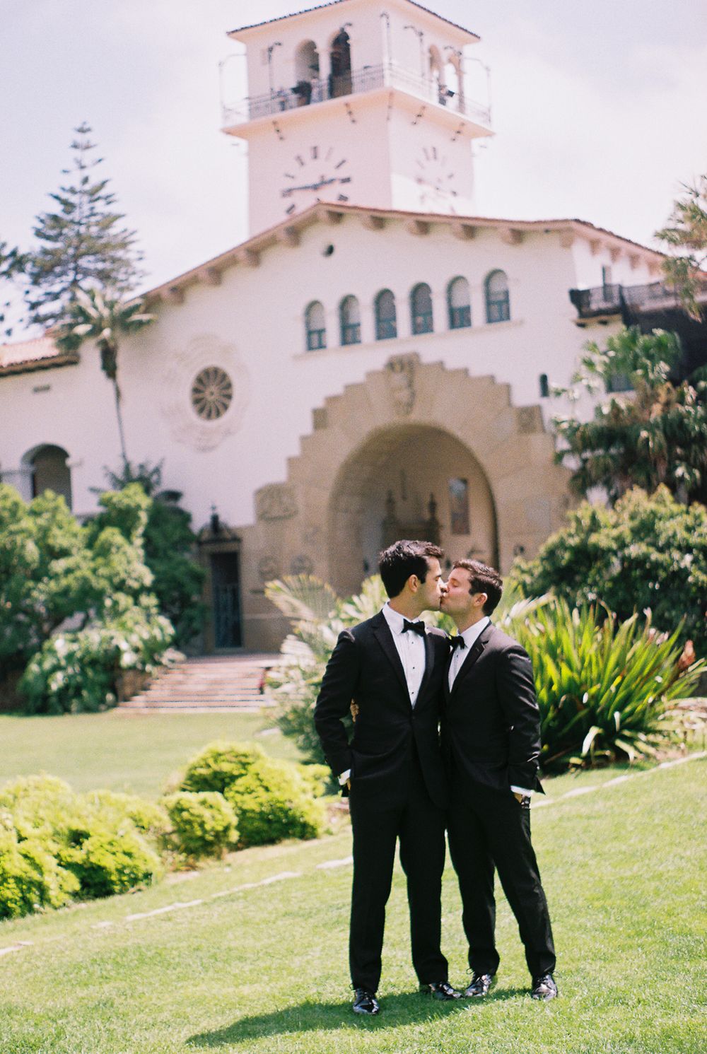 Two grooms sharing a quiet moment beneath the Spanish-Moorish arches of the Santa Barbara Courthouse.
