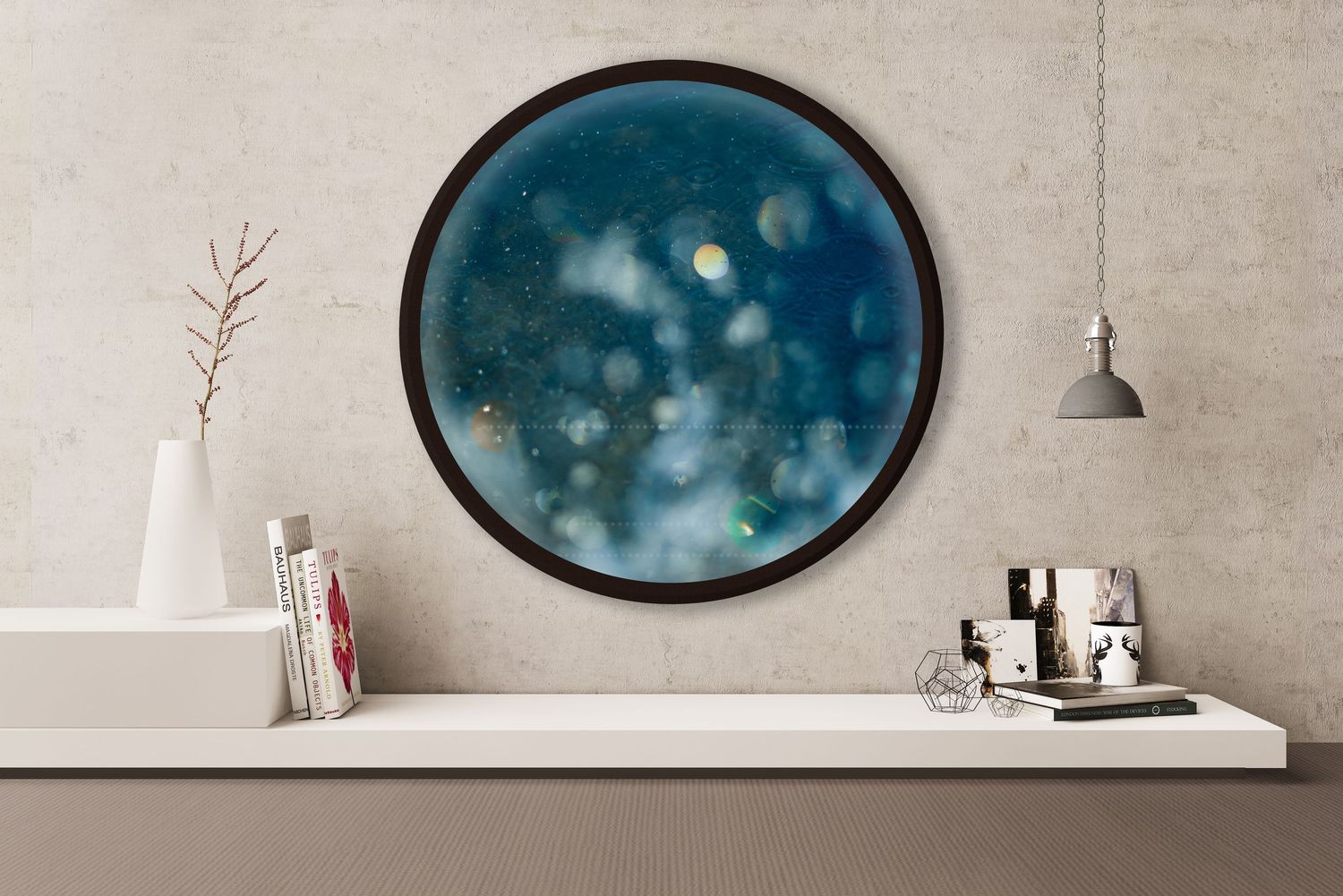 Round framed blue bokeh abstract wall art hanging above a minimalist white shelf with decorative objects.