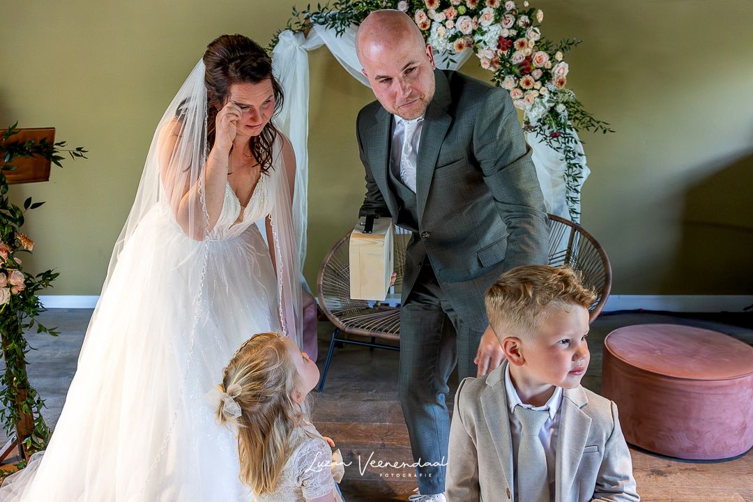 Emotioneel moment tijdens de trouwceremonie van Jesse en Sharon bij Zoomers aan het Bos in Castricum, waar hun kinderen de ringen brengen en