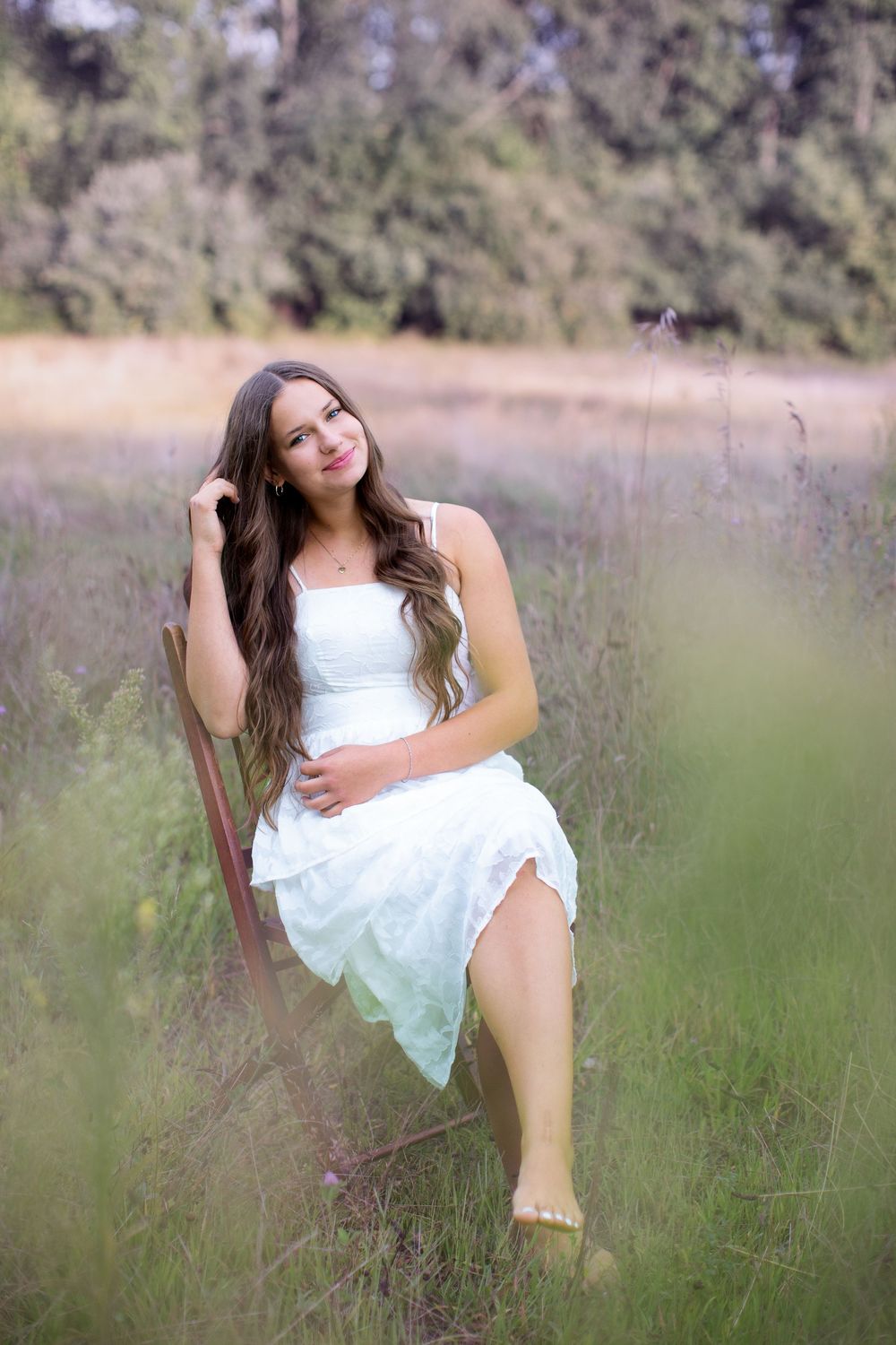 Senior portrait at Island Lake Recreation near Brighton Michigan; girl sitting in chair in flower field by South Lyon, Michigan photographer