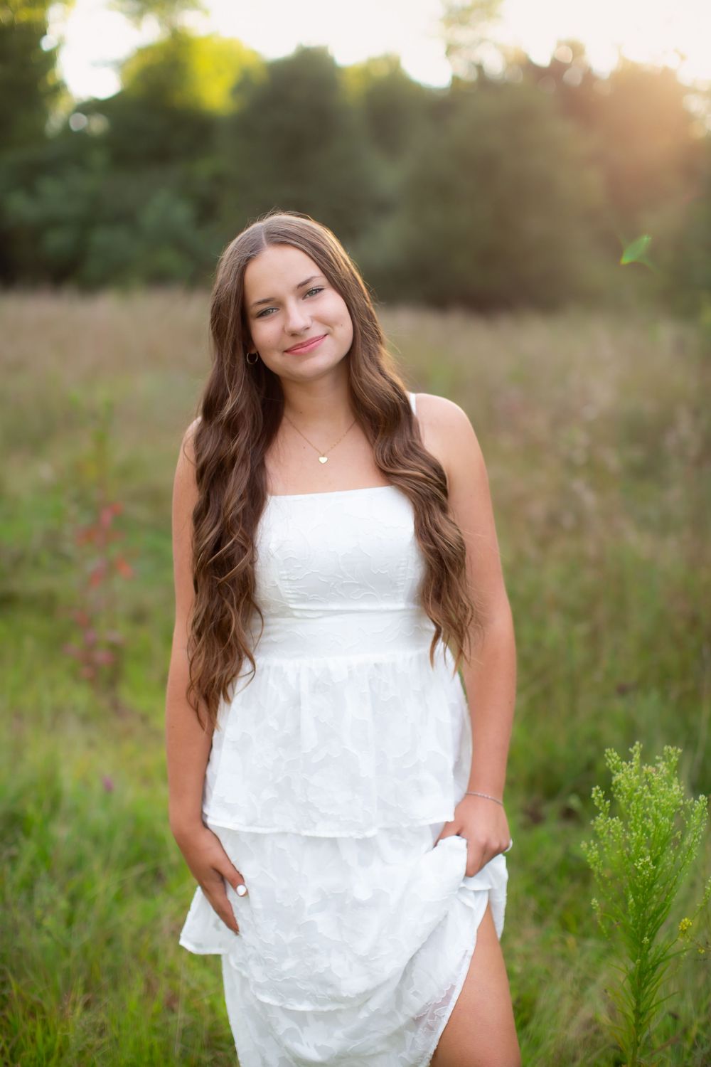 Island Lake Senior photos near Brighton Michigan; girl standing in flower field at golden hour by South Lyon, Michigan photographer