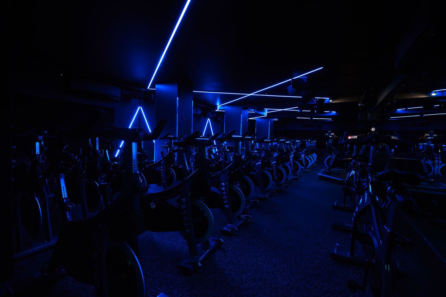 Neon sign reading Stronger Together on a black brick wall in a modern interior space.